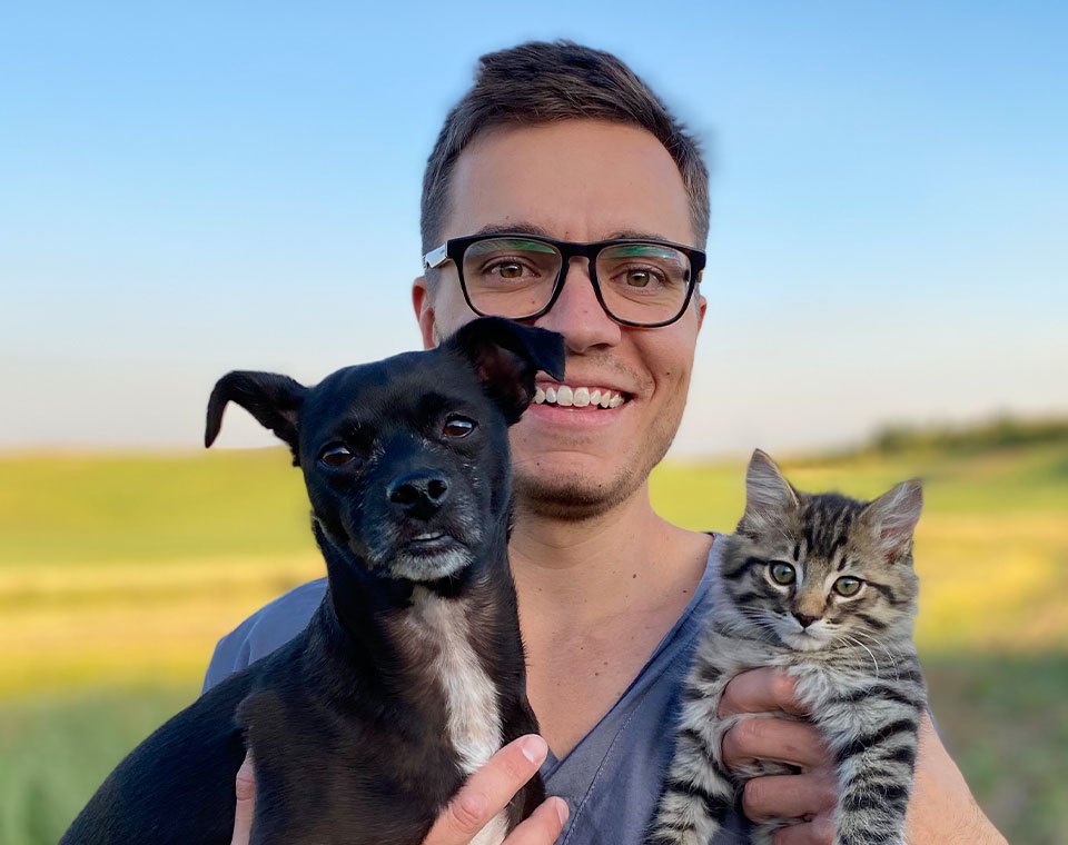 veterinarian with a dog and a cat in his arms